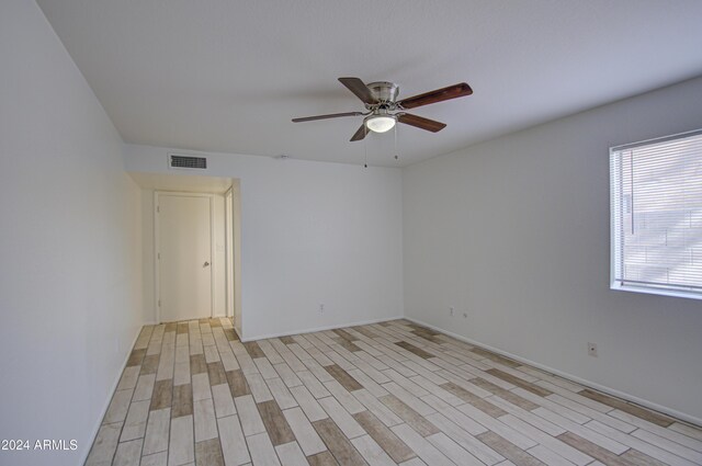 empty room with light wood-type flooring and ceiling fan