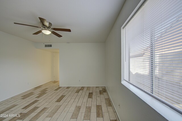 spare room with ceiling fan and light wood-type flooring