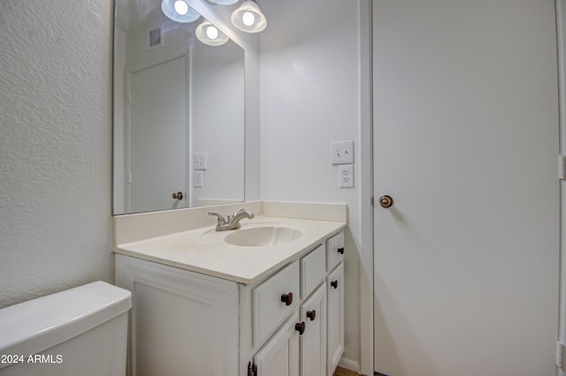 bathroom featuring vanity and toilet