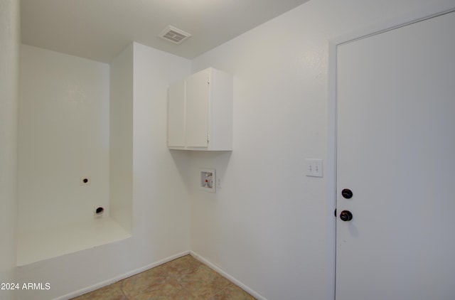 laundry area featuring cabinets, hookup for a washing machine, hookup for an electric dryer, and light tile patterned flooring