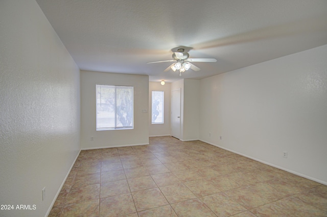 spare room featuring ceiling fan and light tile patterned flooring