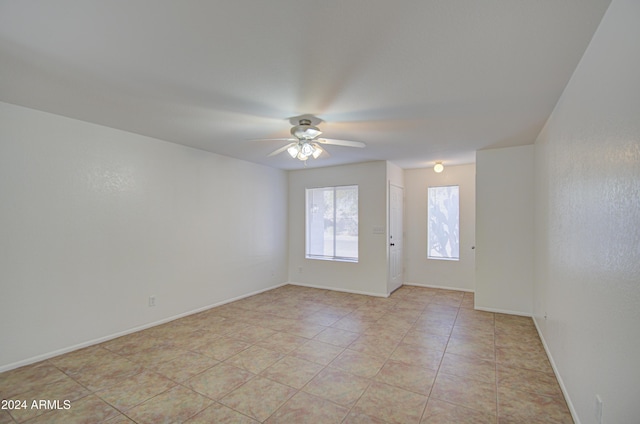 tiled spare room featuring ceiling fan