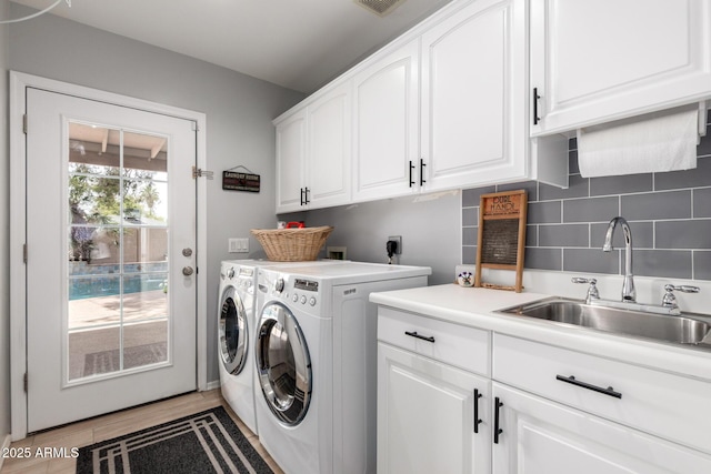 laundry area with cabinet space and separate washer and dryer