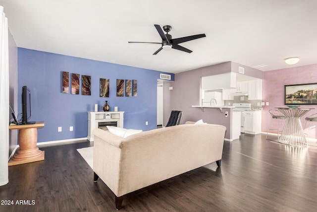 living room featuring ceiling fan, sink, and dark wood-type flooring