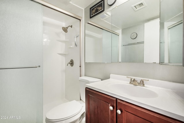 bathroom with toilet, vanity, and walk in shower