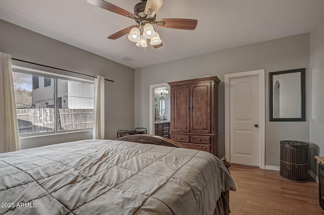 bedroom featuring ensuite bath, ceiling fan, and light hardwood / wood-style flooring