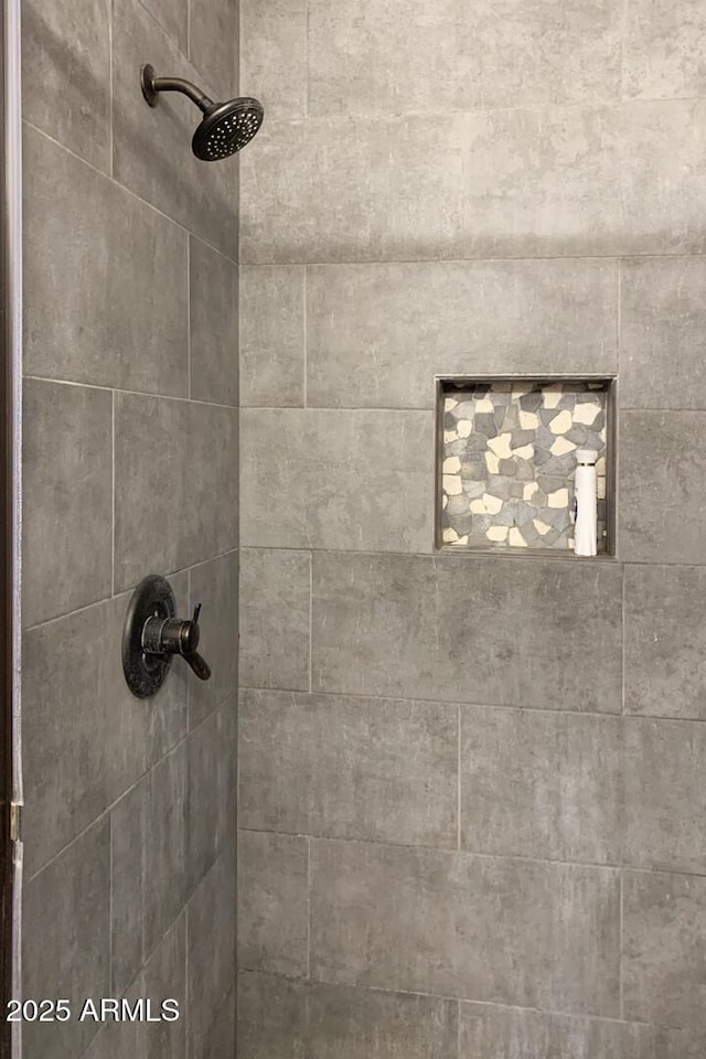 interior details featuring a tile shower