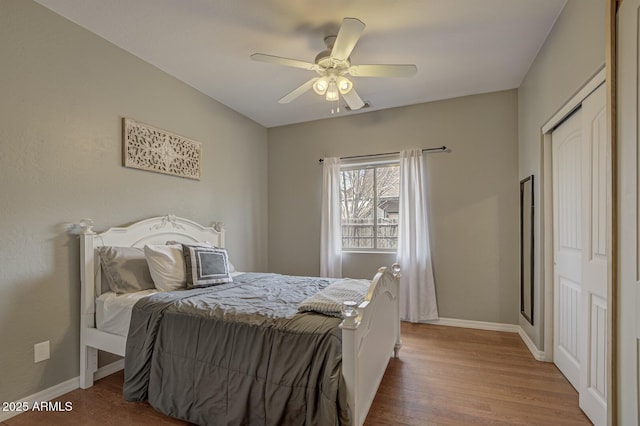 bedroom featuring ceiling fan, wood-type flooring, and a closet