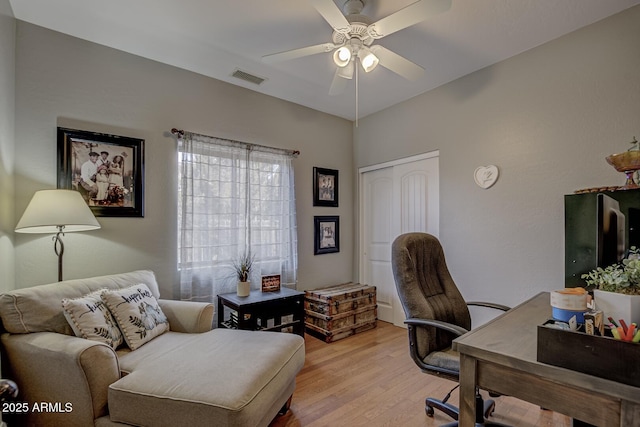 office with light hardwood / wood-style flooring and ceiling fan