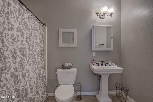 bathroom with tile patterned flooring, a shower with curtain, and toilet