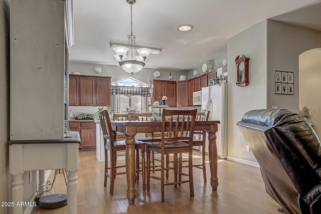 dining room featuring a notable chandelier and light hardwood / wood-style flooring