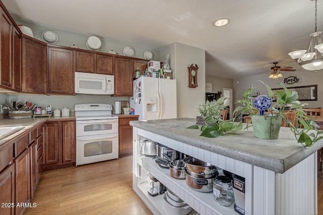 kitchen featuring pendant lighting, ceiling fan, light wood-type flooring, and white appliances