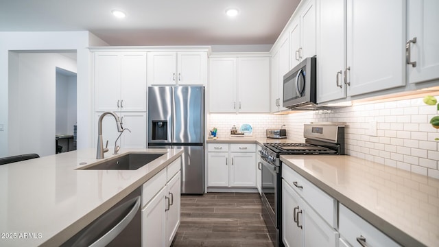 kitchen featuring backsplash, sink, white cabinets, and stainless steel appliances