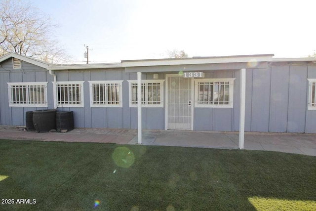 rear view of property featuring a yard and a patio area