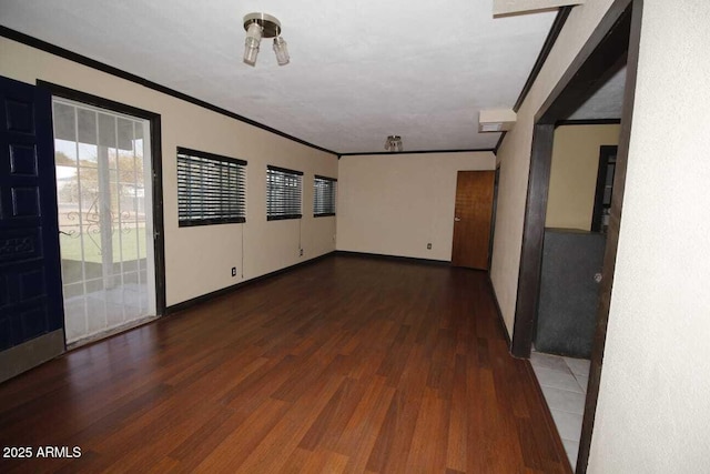 empty room featuring dark hardwood / wood-style flooring and crown molding