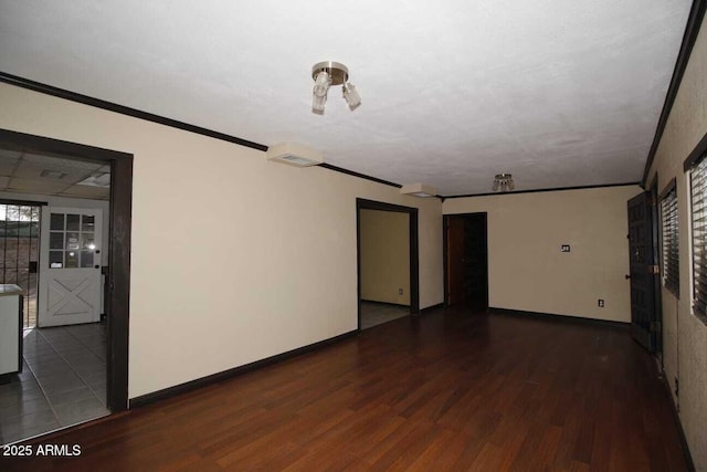 spare room featuring ornamental molding and dark hardwood / wood-style floors