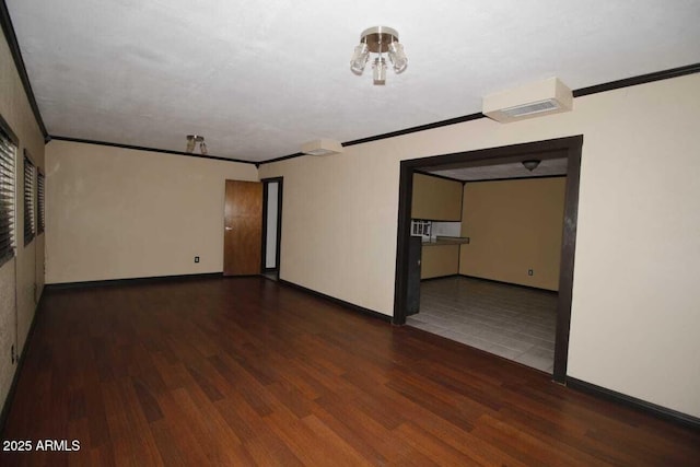 spare room with crown molding and dark hardwood / wood-style flooring