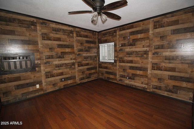 unfurnished room featuring ceiling fan, dark hardwood / wood-style floors, wooden walls, and a wall unit AC