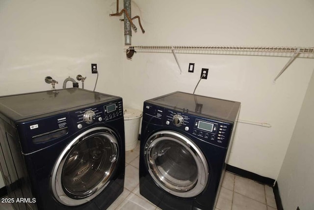 laundry area featuring washer and dryer and light tile patterned floors