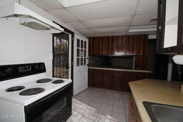 kitchen featuring a drop ceiling and range with electric stovetop