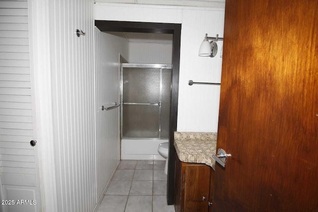 bathroom with tile patterned flooring, shower / bath combination with glass door, and toilet