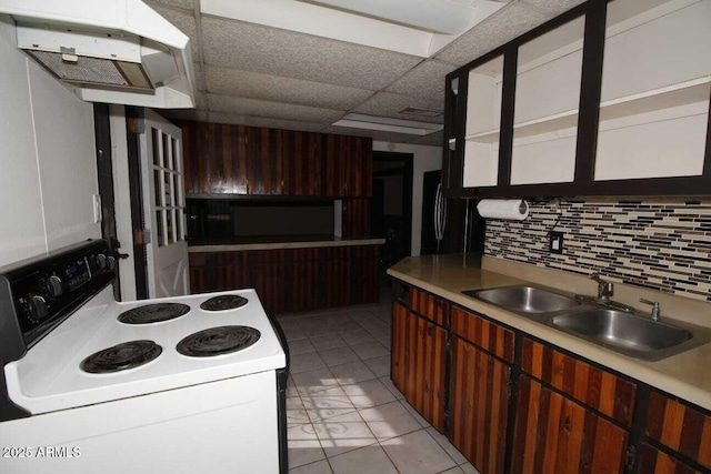 kitchen with sink, black fridge, a paneled ceiling, decorative backsplash, and white range with electric stovetop