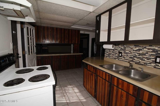 kitchen featuring sink, a paneled ceiling, black refrigerator, decorative backsplash, and white range with electric stovetop