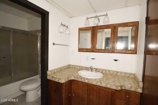 full bathroom featuring toilet, vanity, shower / bath combination with glass door, and tile patterned flooring