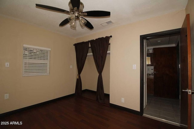 unfurnished room with dark hardwood / wood-style flooring and ceiling fan