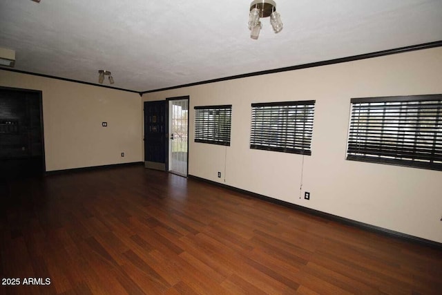 empty room featuring ornamental molding and dark wood-type flooring