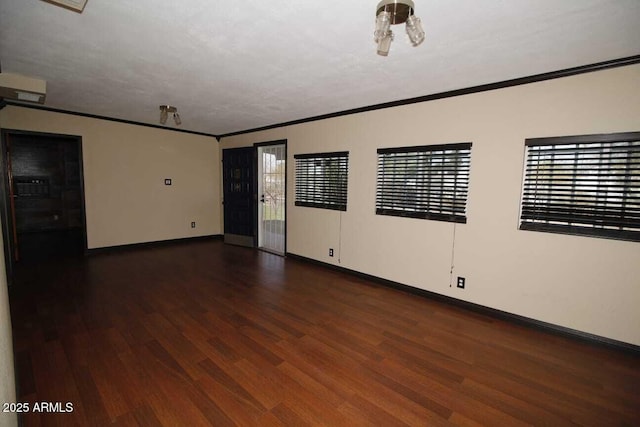 spare room featuring crown molding and dark hardwood / wood-style floors