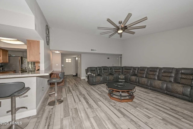 living area with light wood-style floors, ceiling fan, and visible vents