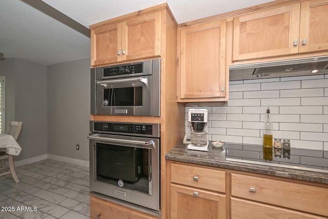 kitchen with tasteful backsplash, baseboards, dark stone countertops, marble finish floor, and stainless steel double oven