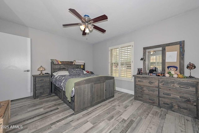 bedroom featuring light wood-style floors, baseboards, and a ceiling fan