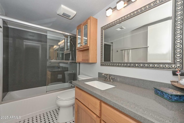 bathroom with visible vents, vanity, toilet, and enclosed tub / shower combo