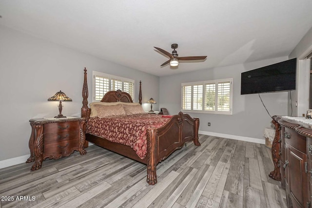 bedroom featuring multiple windows, light wood-style flooring, and baseboards