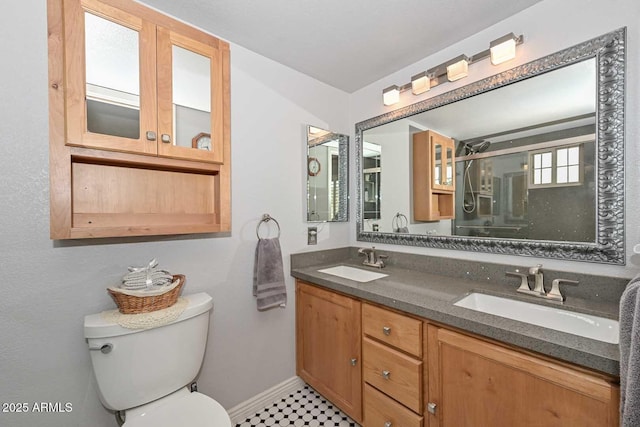 bathroom with a stall shower, a sink, toilet, and double vanity