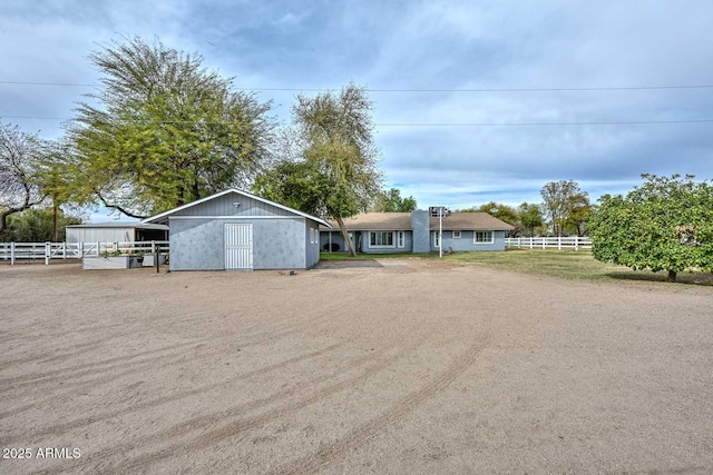 view of front of property with fence and an outdoor structure