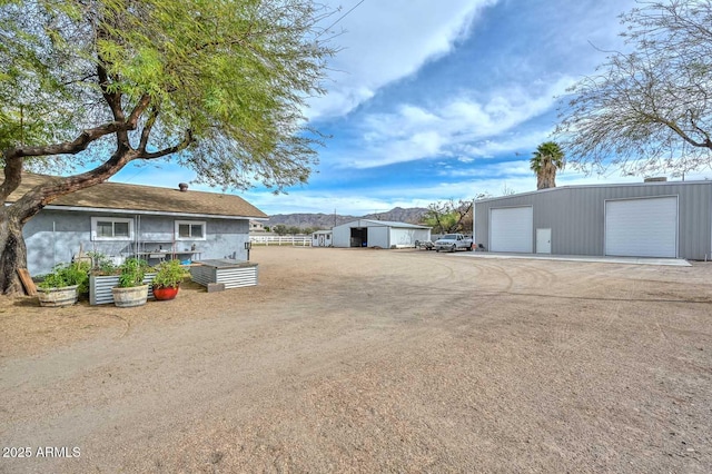 view of yard featuring a garage, an outdoor structure, and fence