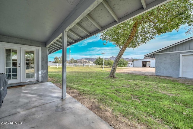 view of yard featuring french doors, a patio area, and fence