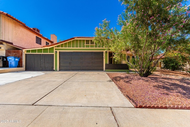 2109 E Gelding Dr, Phoenix, AZ 85022 - view of front facade with driveway, an attached garage, a chimney, and board and batten siding