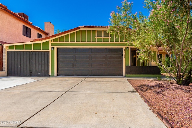 2109 E Gelding Dr, Phoenix, AZ 85022 - view of front of house with a chimney, driveway, an attached garage, and board and batten siding