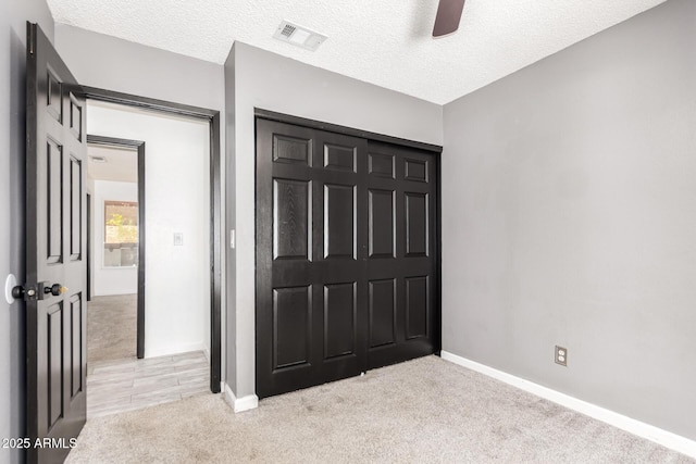 2109 E Gelding Dr, Phoenix, AZ 85022 - unfurnished bedroom with light carpet, a closet, a textured ceiling, and a ceiling fan