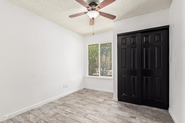 2109 E Gelding Dr, Phoenix, AZ 85022 - unfurnished bedroom featuring a textured ceiling, wood finished floors, a ceiling fan, and a closet