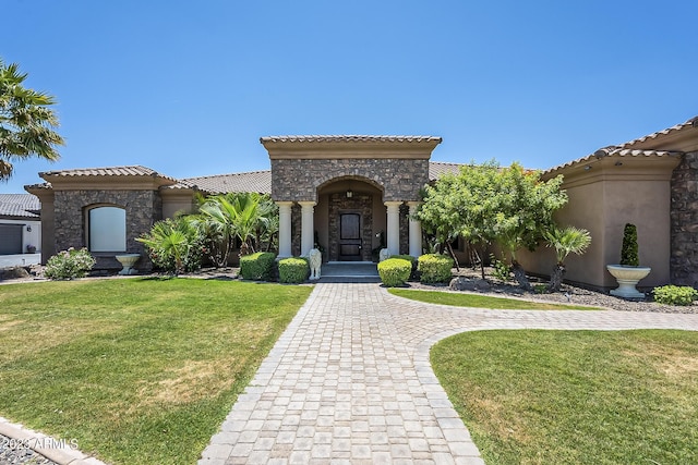 mediterranean / spanish house featuring a front lawn