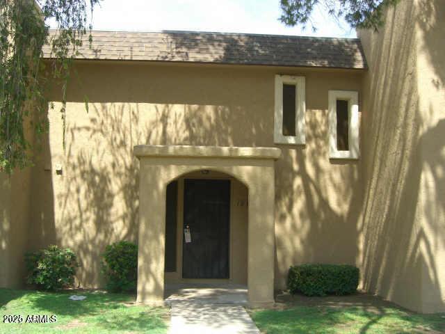 entrance to property with roof with shingles