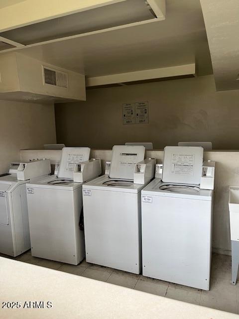 shared laundry area with light tile patterned floors, visible vents, and washing machine and clothes dryer