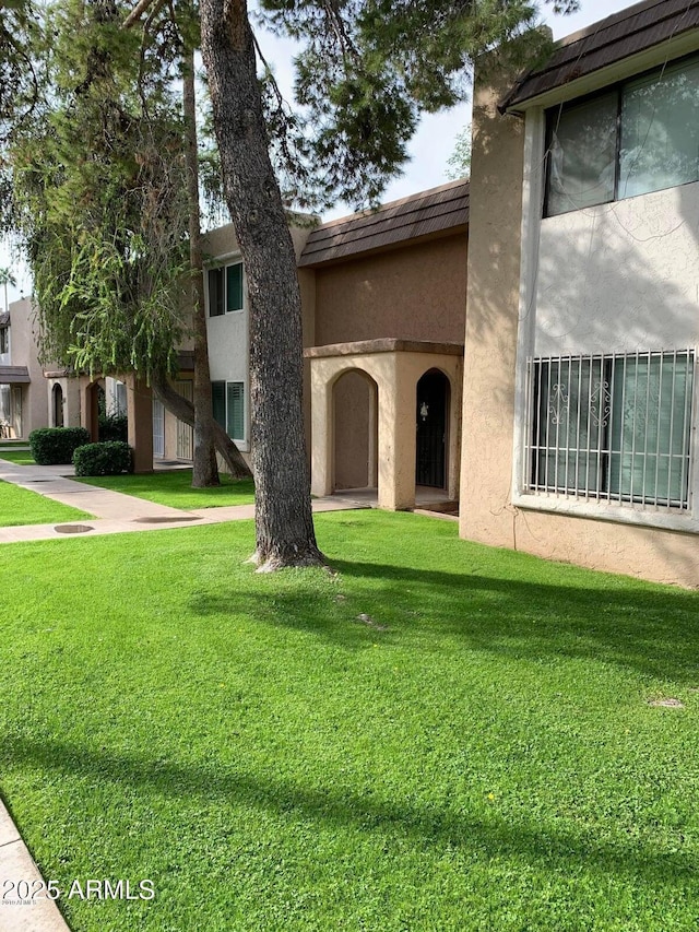 multi unit property with a front yard and stucco siding