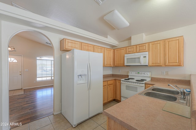 kitchen with white appliances, sink, light hardwood / wood-style floors, vaulted ceiling, and light brown cabinets