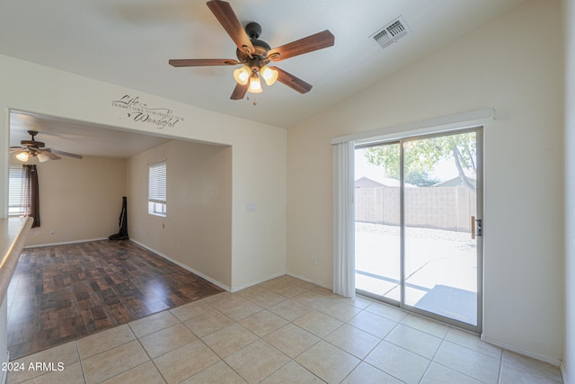 empty room with light hardwood / wood-style flooring, a healthy amount of sunlight, lofted ceiling, and ceiling fan